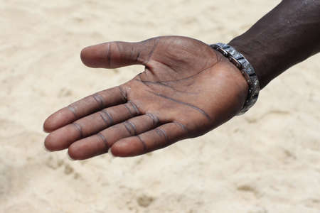  Open hand of the black man on a background of sandの写真素材