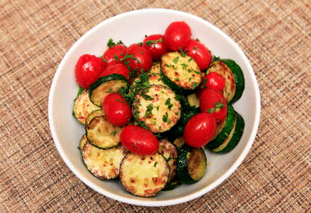 Fried zucchini and tomatoes with herbsの写真素材