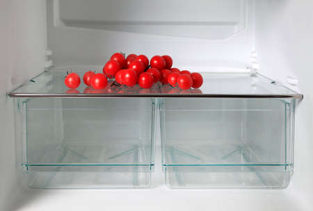Empty refrigerator with fresh tomatosの写真素材
