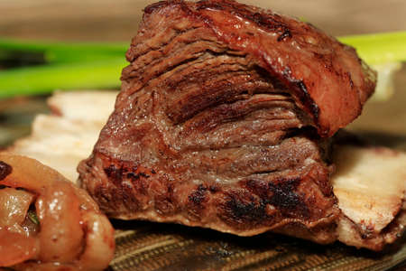 Roast red beef meat bbq bloc served on black plate with green chivesの写真素材