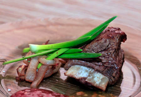 Roast red beef meat bbq bloc served on black plate with green chivesの写真素材