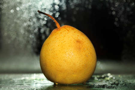 Yellow pear on a dim backgroundの写真素材