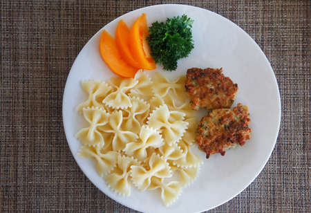 Chicken cutlets with pasta and fresh tomatoesの写真素材