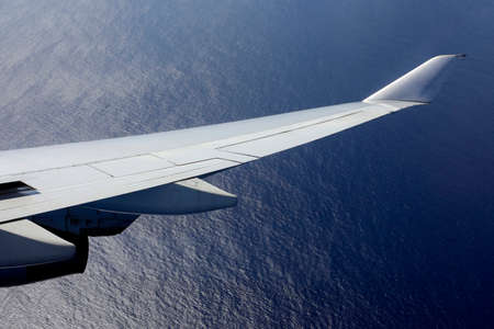 Wing of the plane on a background of oceanの写真素材