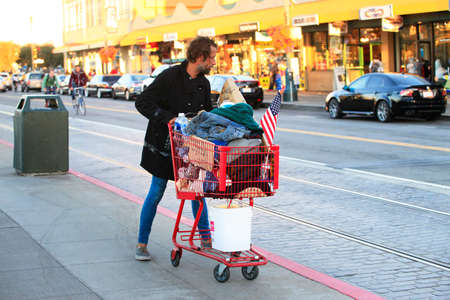 San Francisco, CA, USA - September 24, 2013: Homeless Man with Shopping Cart on the streets in San Francisco. He carries all of his belongings with him in a shopping cartのeditorial素材