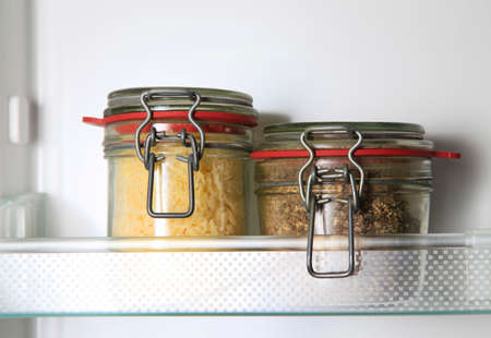 Glass jars on the shelf of the refrigeratorの写真素材