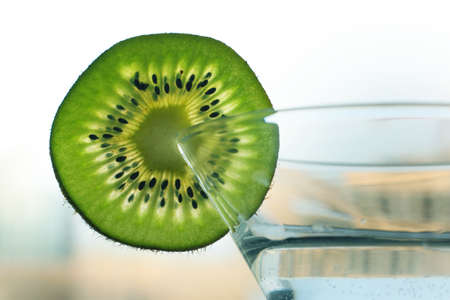 Glass with a plate kiwi on a dim backgroundの写真素材