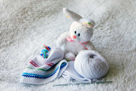 Baby hat from viscose and knitting hooks. Needlework accessories isolated on white background.