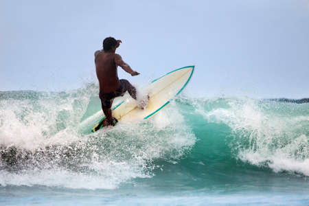 Surfer in ocean on sunset. Bali. Indonesia