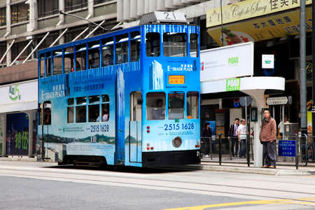 Hong Kong, HKG - March 28, 2012: Double-deck bus with skyscrapers in Hong Kong, China. The Double-deck trams system in Hong Kong is one of three and the most famous in the world.のeditorial素材
