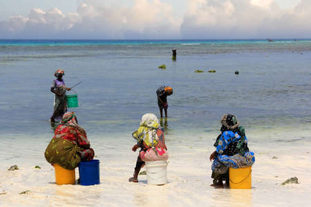 Nungwi, Zanzibar, Tanzania - January 11, 2016:  African women in traditional dress on the beach of village Nungwi. Zanzibar, Tanzaniaのeditorial素材