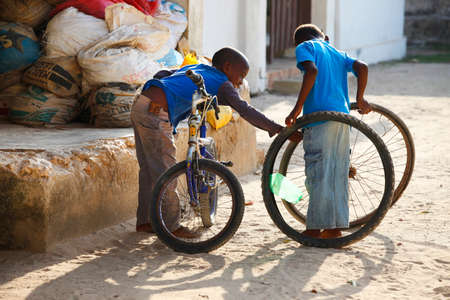 Zanzibar, Tanzania - January 8, 2016: two unknown African boy playing in the street in the village of Jambiani, Zanzibar. Tanzaniaのeditorial素材