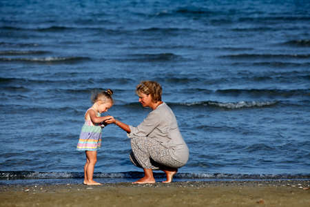 Grandmother with a little granddaughter on the beachの写真素材