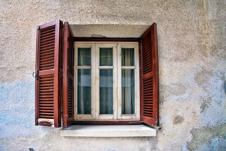 Old wooden window on stone wallの写真素材