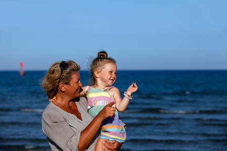 Grandmother with a little granddaughter on the beachの写真素材