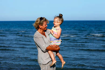 Grandmother with a little granddaughter on the beachの写真素材