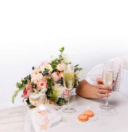 Two glasses with champagne, boutonniere with roses and cookiesの写真素材