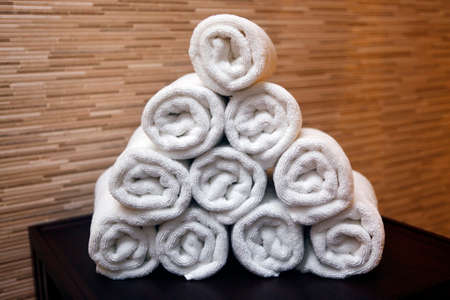 Freshly washed rolled towels isolated on wallの写真素材