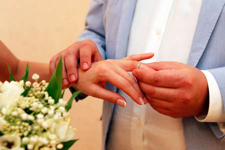 Groom wears a wedding ring to the brideの写真素材