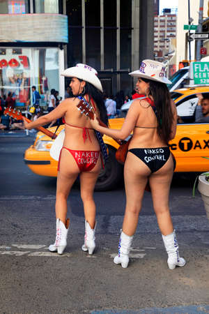 New York City, USA - May 17, 2013: New York City, two naked cowgirls in bikini play guitar on times square manhattan new york cityのeditorial素材