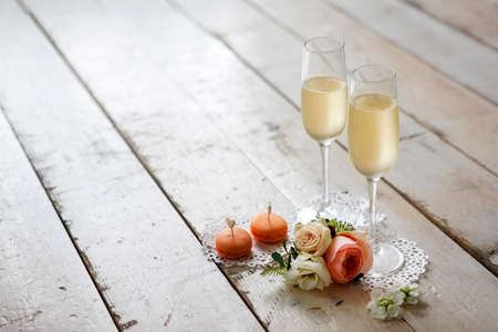 Two glasses with champagne, boutonniere with roses and cookiesの写真素材