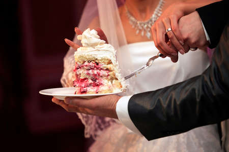 The groom and the bride cut a wedding pieの写真素材