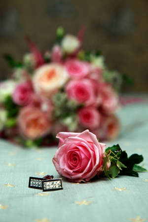 Beautiful wedding bouquet from pink roses and groom cufflinks