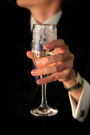 Glass of champagne in a hand of the groomの写真素材