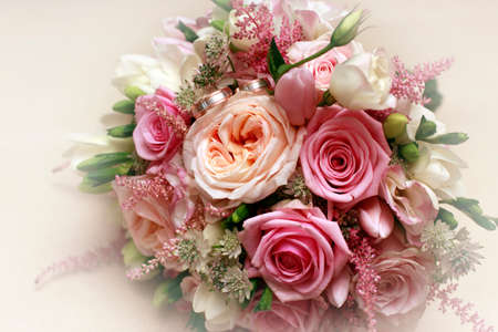 Beautiful wedding bouquet from pink roses and wedding ringの写真素材