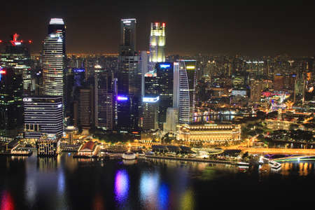 Singapore, Singapore - October 2, 2016: Night view of the Marina Bay skyline from the Marina of Singapore at night . People are on the promenade that is full of restaurant and shops.のeditorial素材
