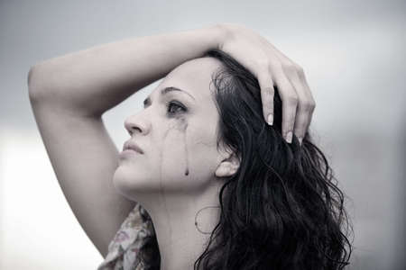 Portrait of a young crying brunetteの写真素材