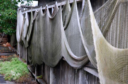 Fishing nets drying on the fenceの写真素材