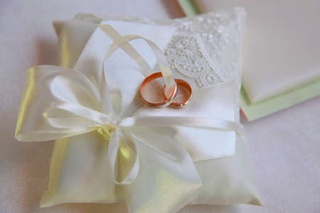 Wedding rings on a satiny fabricの写真素材