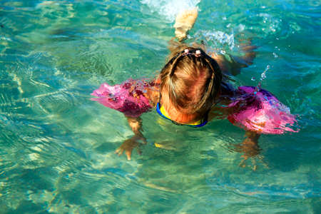 Little girl dives in the clear seaの写真素材