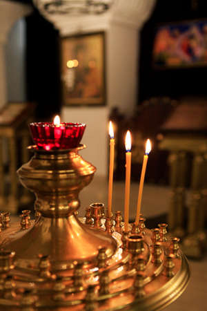 Interior of russian orthodox church. Candles under the ancient icon framed with the gold.の写真素材