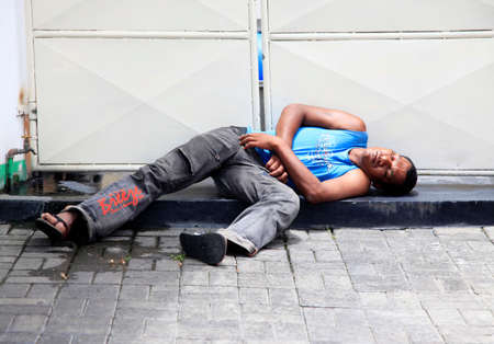 Pereber, Mauritius - January 23, 2012 : A homeless man sleeps on the sidewalk in city Pereber on Mauritiusのeditorial素材