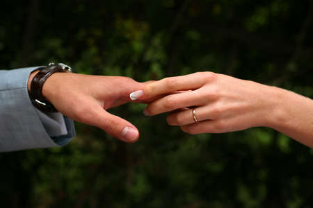 Female hands in man's hands on a dark backgroundの写真素材