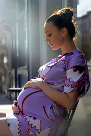 Beautiful pregnant woman in cafeの写真素材