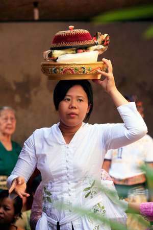 Ubud, Indonesia - October 31, 2008: The traditional Hindu ceremony, girl with a basket on her head at an Indonesian weddingのeditorial素材