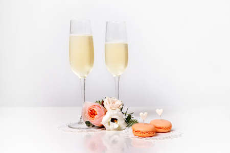 Two glasses with champagne, boutonniere with roses and cookiesの写真素材