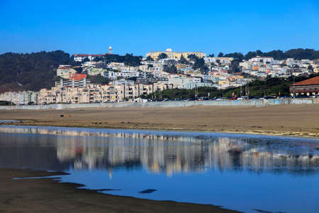 Ocean Beach in San Francisco with reflection of the city on wet sandの写真素材