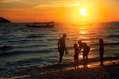 Family on the beach at sunsetの写真素材