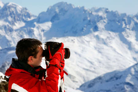 The photographer works on a background of mountains of Elbrusの写真素材