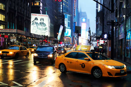 New York, USA - May 20, 2013: taxi's crossing at Time Square at night in the rain. The site is regarded as the world's most visited tourist attraction with nearly 40 million visitors annually.のeditorial素材