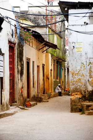 Stone Town, Tanzania - January 10, 2016: A man sits at the door of his shop with gifts for tourists in Stone Town, Zanzibar. Tanzaniaのeditorial素材