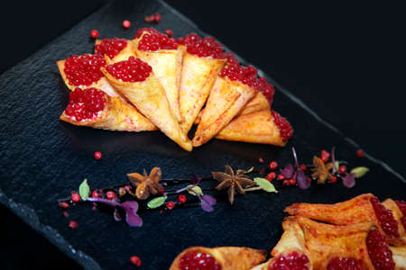 Rabbit pate in crispy horns decorated with spices on a black stone plateの写真素材