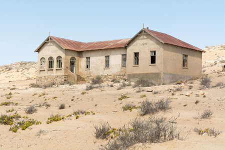 NAMIBIA, KOLMANSKOP - SEPTEMBER, 14. 2014: Ghost Town Kolmanskop, former Diamond Dagger Town in desert stripe near Luederitz. It was used from 1908 till 1930. Now it's abandoned and desertificated. Physician Building.のeditorial素材