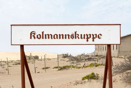 NAMIBIA, KOLMANSKOP - SEPTEMBER, 14. 2014: Ghost Town Kolmanskop, former Diamond Dagger Town in desert stripe near Luederitz. It was used from 1908 till 1930. Now it's abandoned and desertificated. Sign.のeditorial素材