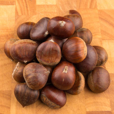 Bunch of autumn seasonal fruits "Spanish Chestnut" on a wooden plate.の写真素材