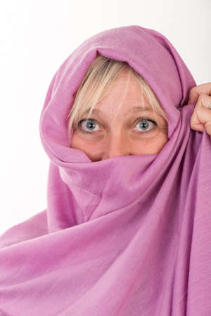 beautiful european mid aged woman hiding her face behind a shawl - studio shot on white background